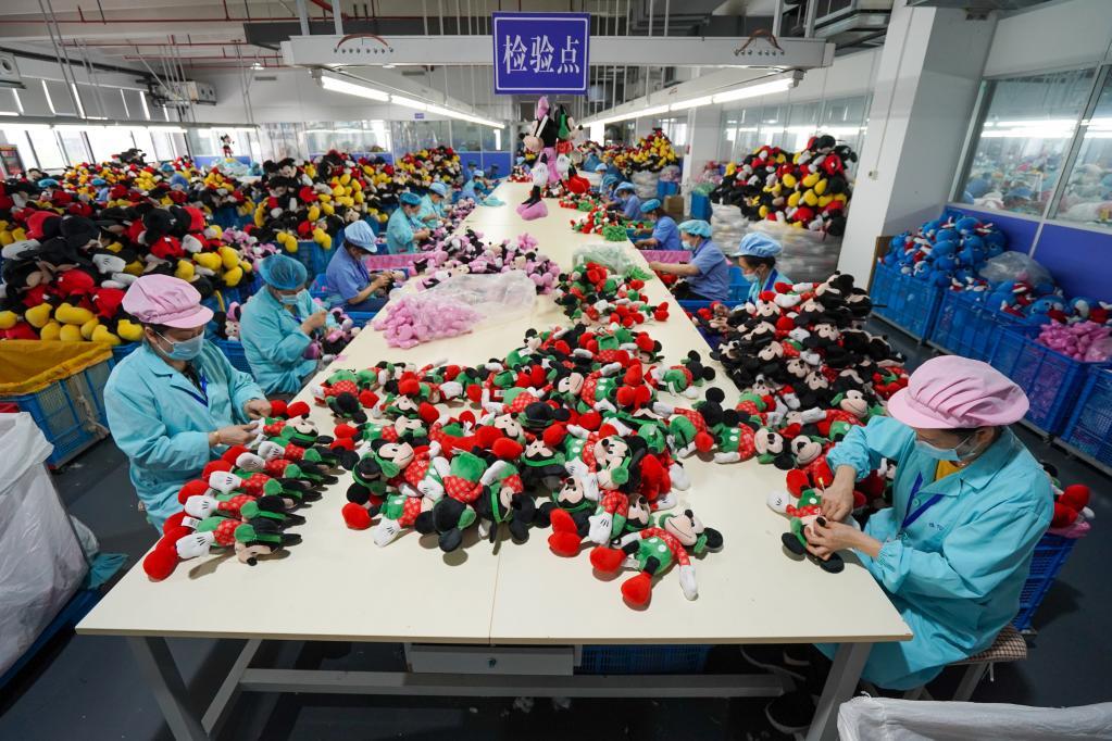 workers inspecting plush toys on a large-scale production line in a China plush toy factory